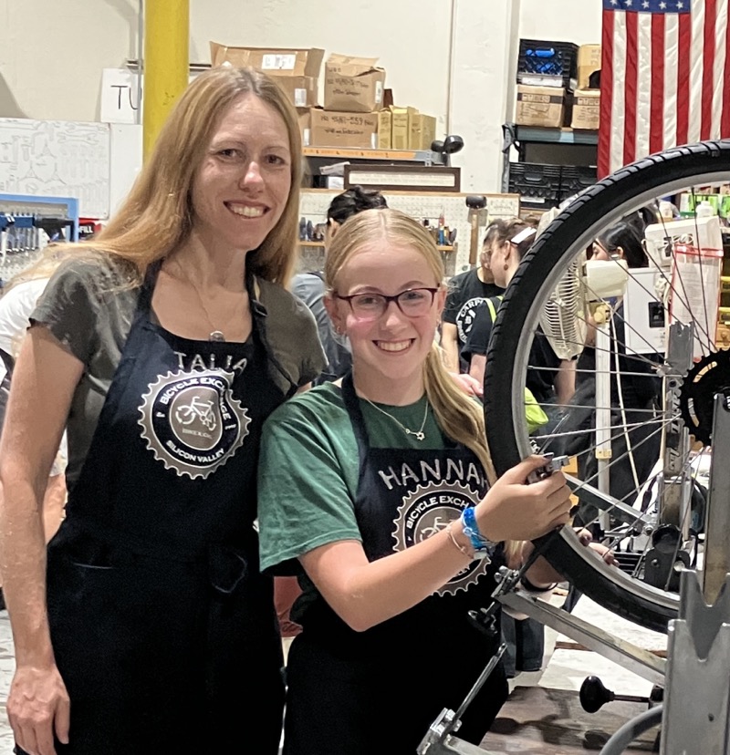 Talia and Hannah wearing their bedazzled aprons, posing in the shop