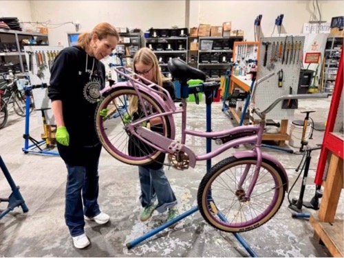 Mother and daughter repairing a bike together in the SVBE shop