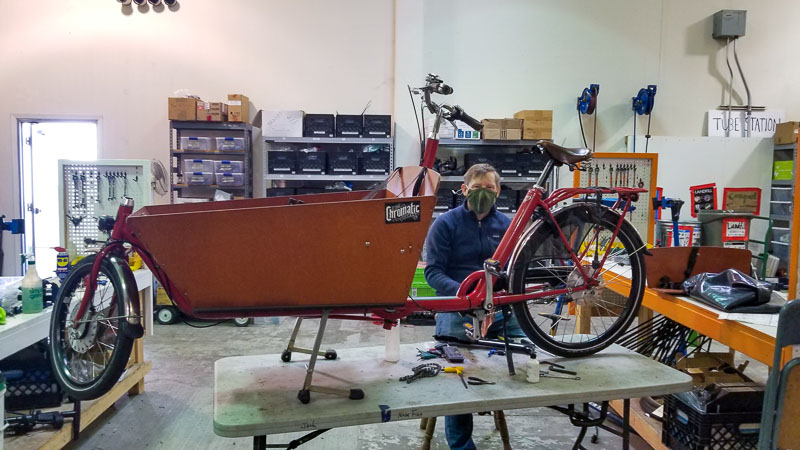 John Garrish refurbishes a cargo bike during a volunteer day. His employer, Guidewire, gives him paid time off to volunteers. 