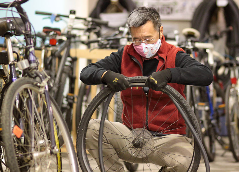Michael Khaw changes a tube on a homework bike. 