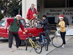 SVBE volunteers wearing Santa hats, making a bike distribution to one of our partners